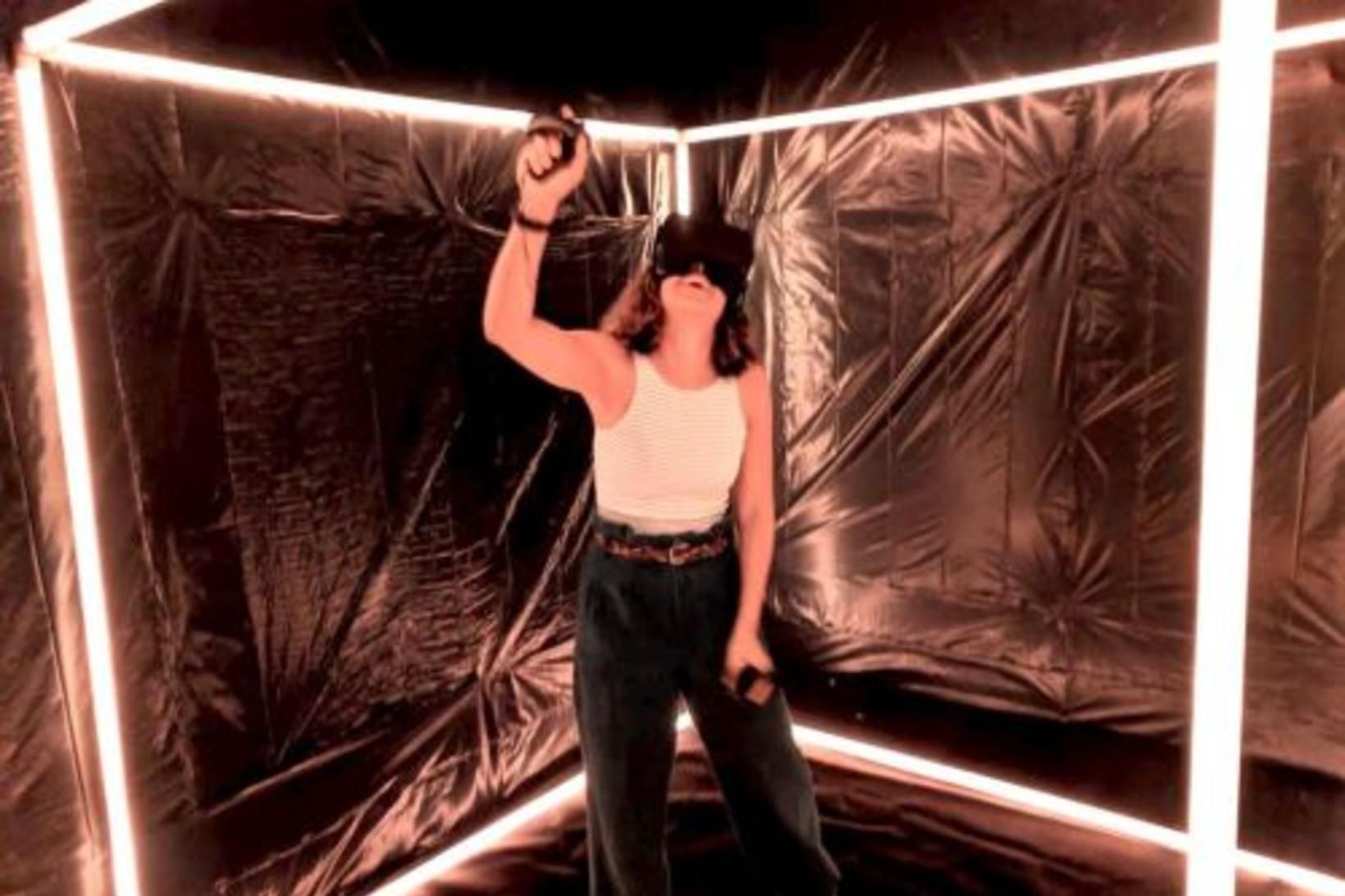 An audience member inside the box, wearing a VR headset